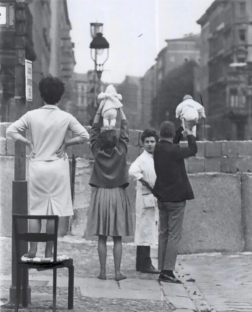 Residents of West Berlin present their children to their grandparents in East Berlin, 1961.