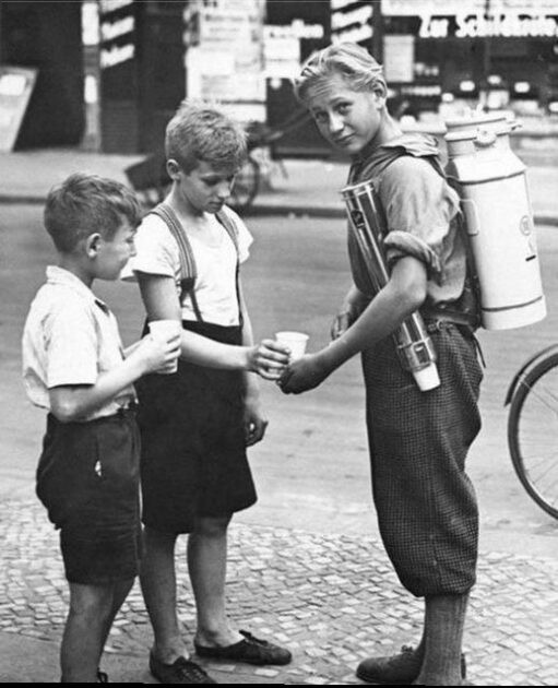 A young boy using a portable lemonade machine to sell lemonade. Berlin, 1931.