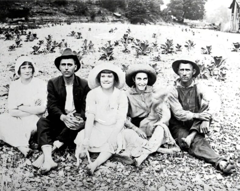 Five individuals are pictured in a group portrait sitting on the dry bed of Pine Lick Creek in Whitleyville