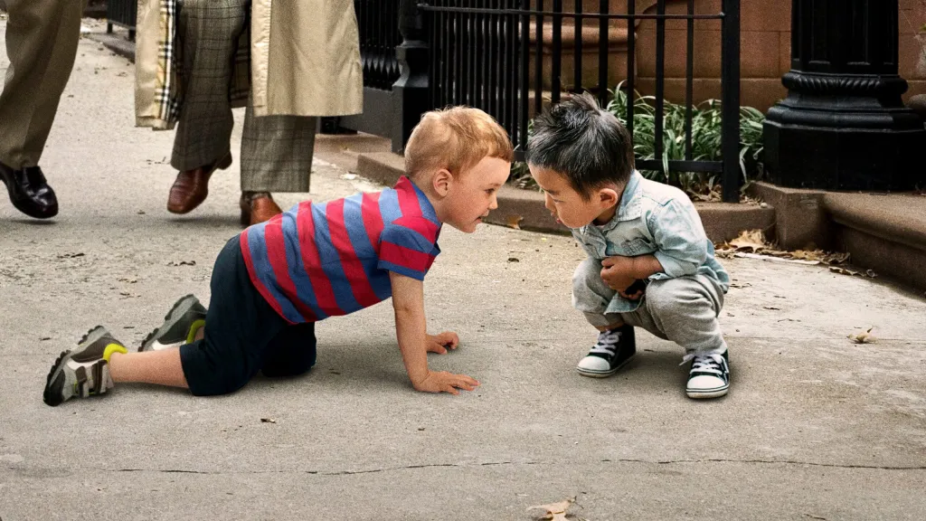 Kids sniffing each other on a Greenville sidewalk as pedestrians pause, per a quirky socialization moment on a busy street.